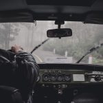 man driving car during rainy daytime
